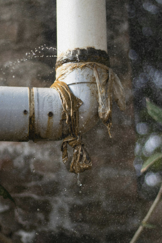 Leaking pipe with temporary repair showing water escaping, illustrating how small maintenance issues can become costly problems in real estate.