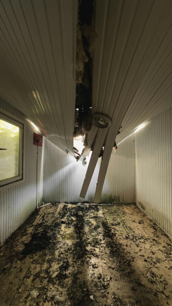 Severe property damage with a collapsed ceiling showing hidden repair costs in real estate investing.