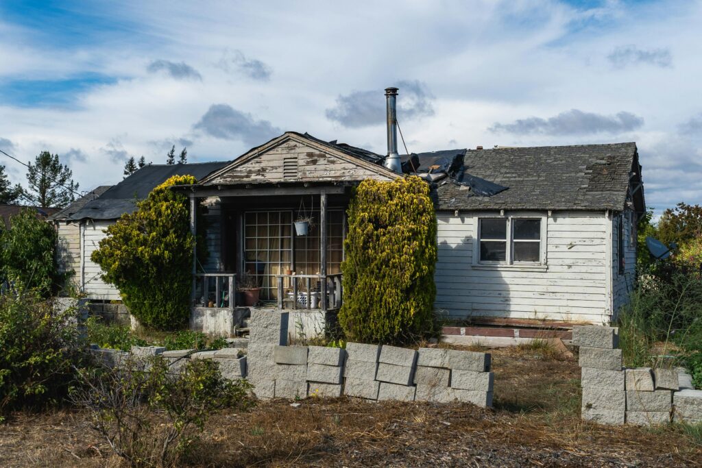 distressed house exterior with visible damage and maintenance issues representing hidden risks in real estate deals