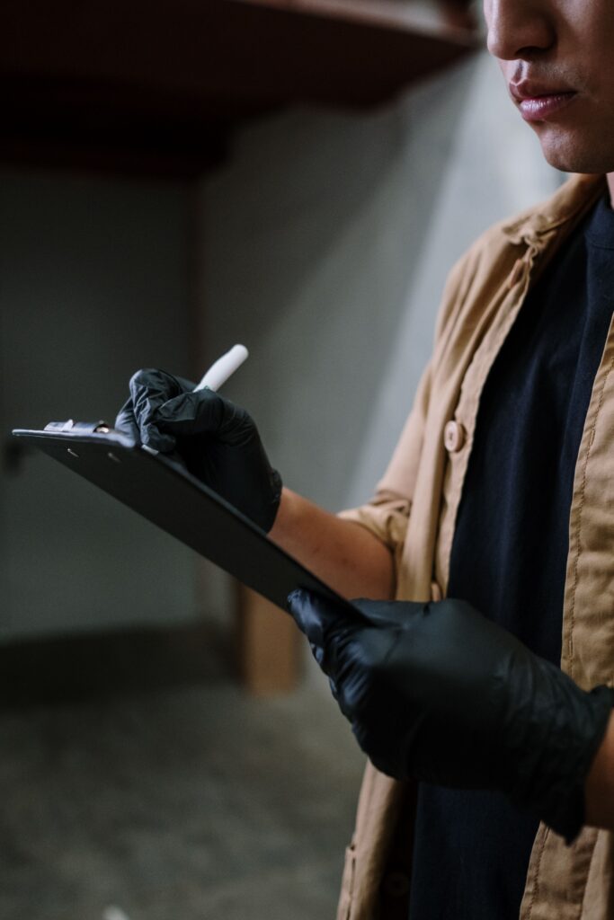 Inspector documenting property condition with a clipboard before renovation begins in a vacant home.